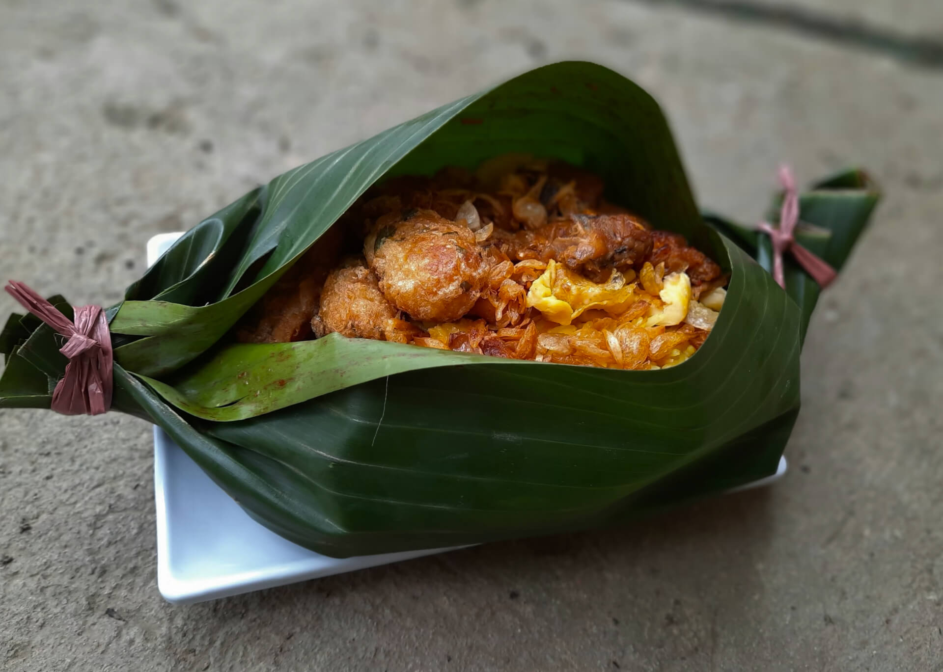Freshly wrapped banana leaf parcels with traditional filling